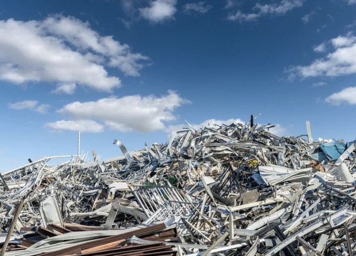 Large pile of scrap metal under a blue sky at TAS Recycling facility