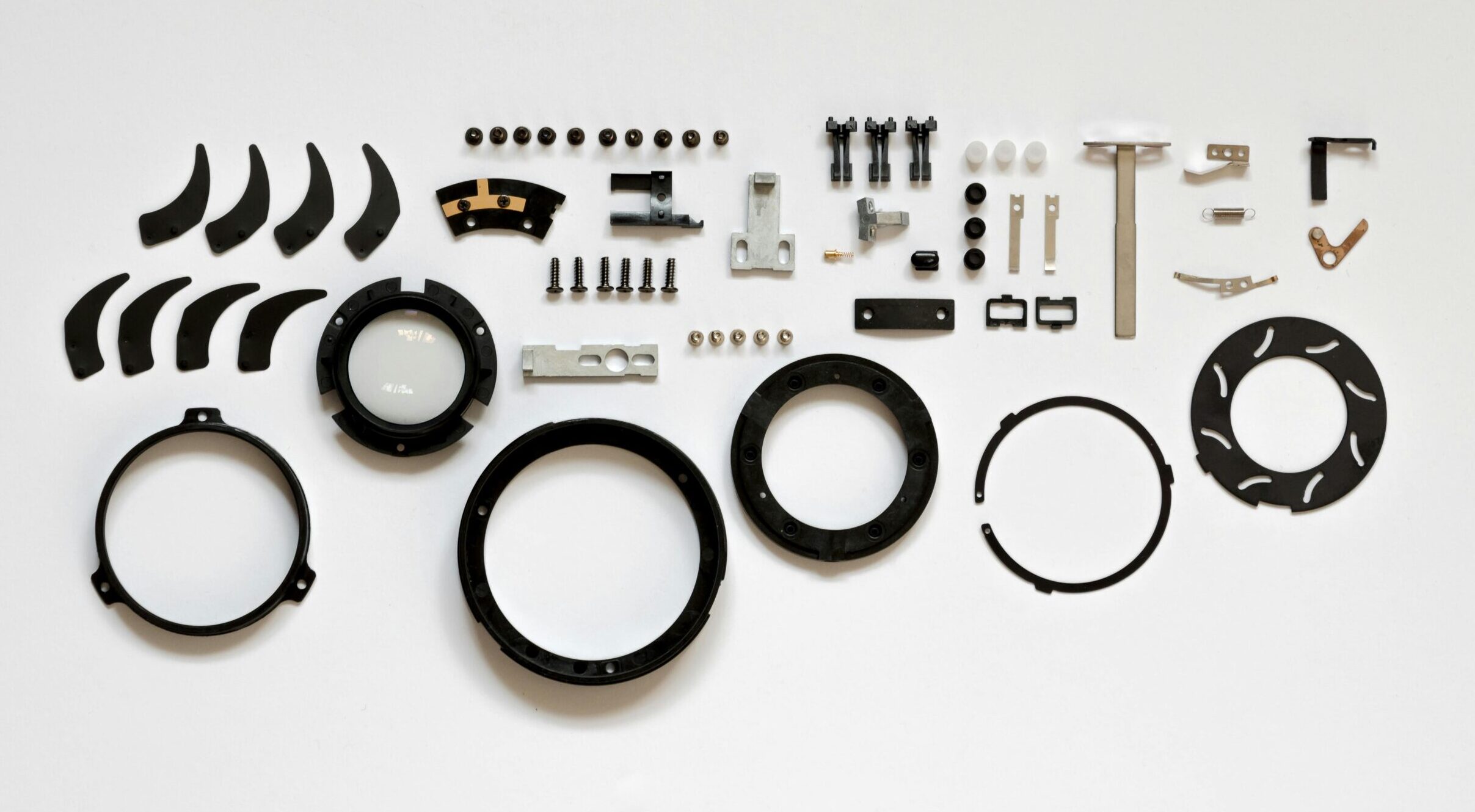 Assorted automotive parts and metal components arranged on a white background