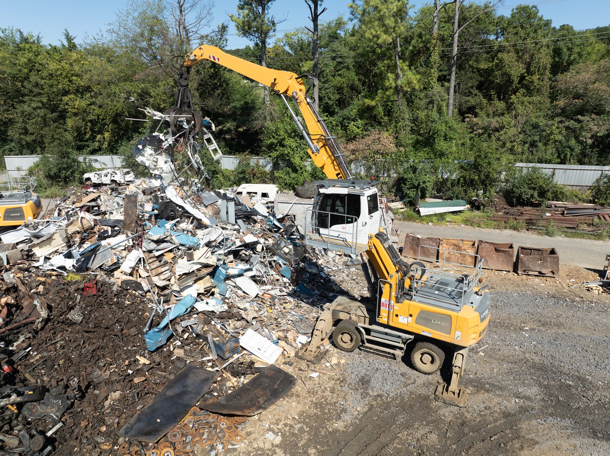 TAS Recycling excavator sorting aluminum and steel scrap materials at the yard.