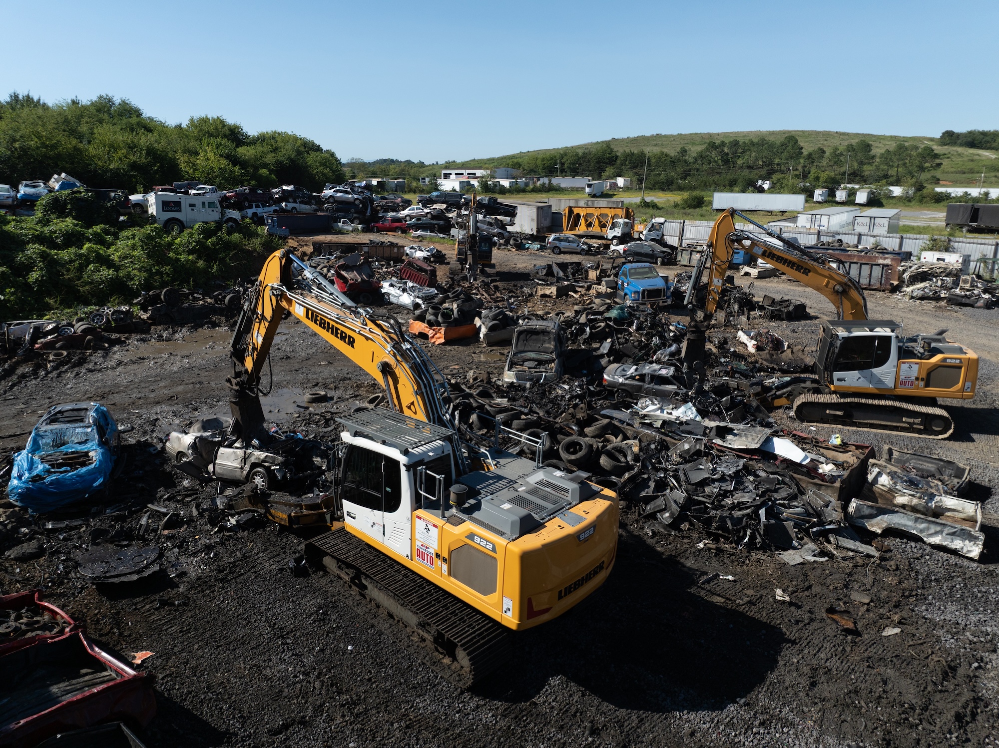 Excavators processing scrap cars and metal at TAS Recycling yard in Tennessee.