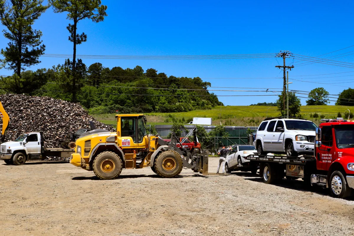 Yellow loader moving junk cars at TAS Recycling yard in Knoxville